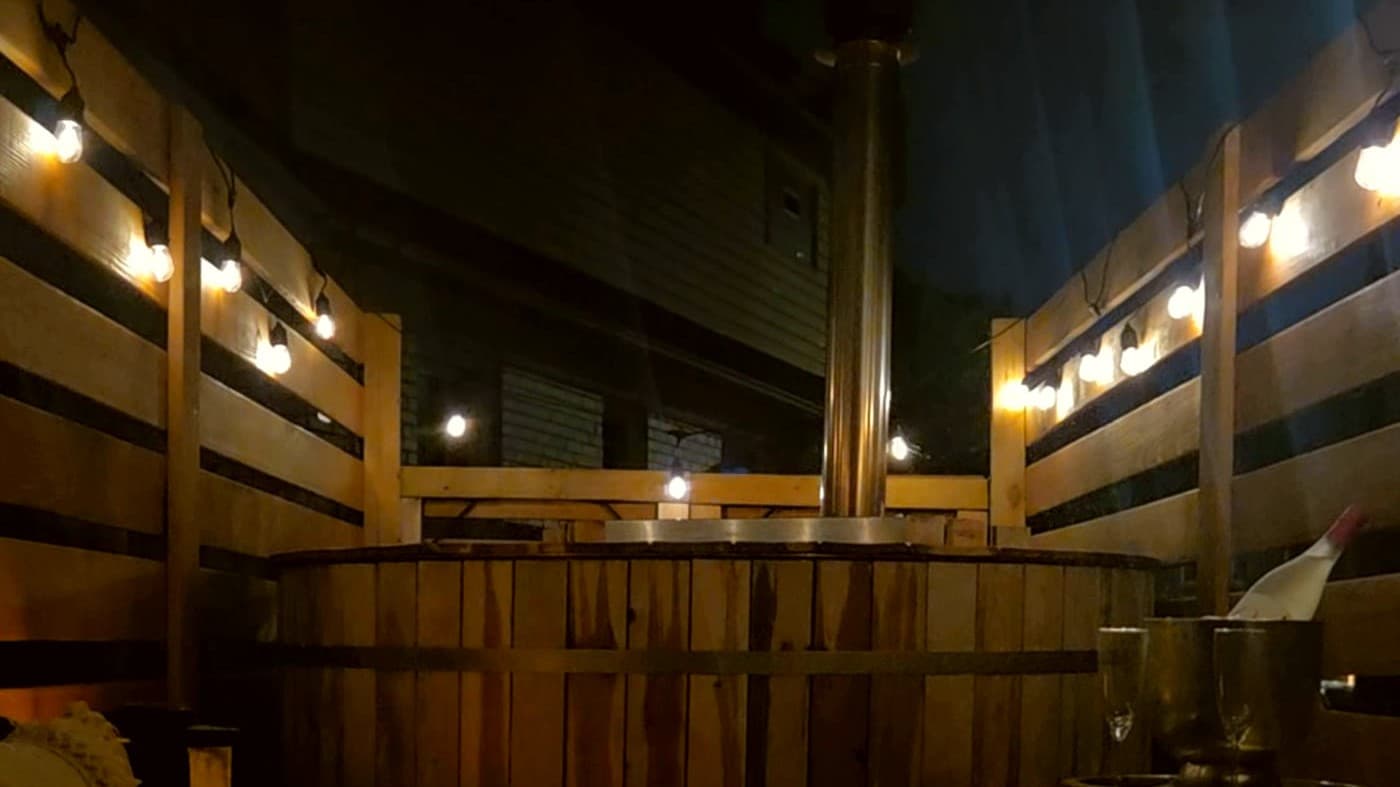 Cedar hot tub deck seating area with lanterns and pillows